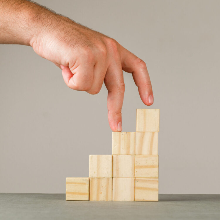 Business growth concept on grey and white background side view. man putting fingers on step stairs.